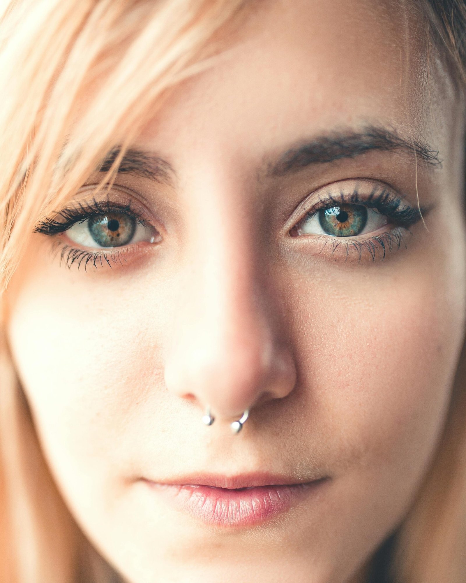 A detailed close-up portrait of a woman with a nose ring and striking eyes, capturing natural beauty.